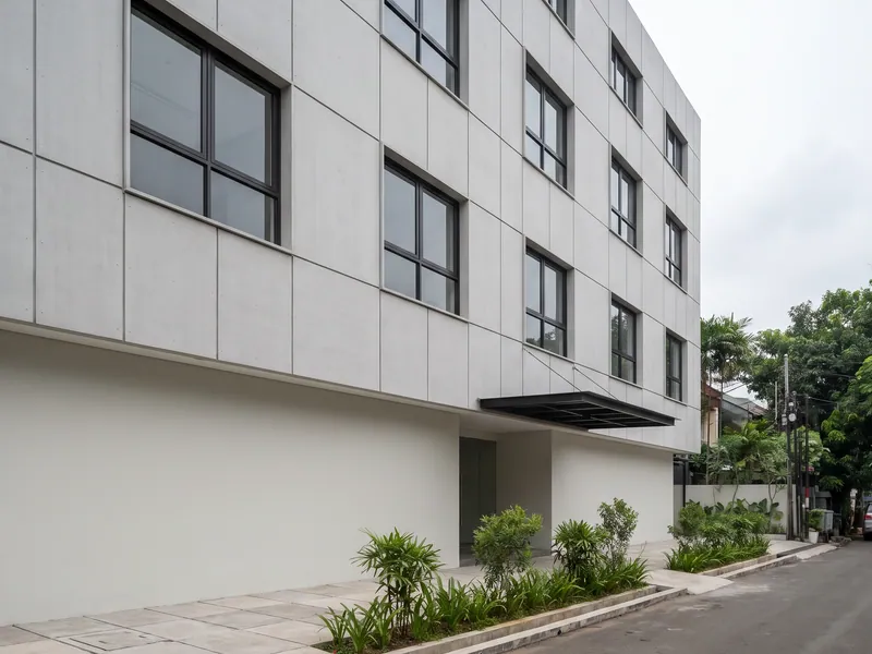 Façade gedung operasional di Serpong setelah renovasi, panel façade baru dan kusen aluminium terpasang rata pada seluruh bidang muka bangunan.