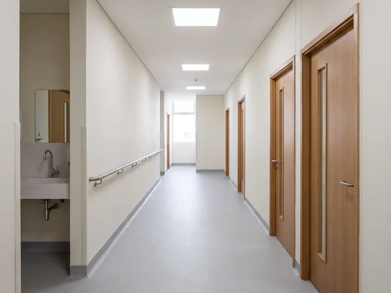 Koridor ruang periksa klinik di Jakarta Barat setelah renovasi, partisi baru, flooring vinyl homogen, dan titik plumbing di setiap ruang sudah berfungsi.